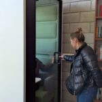 Uczestniczka szkolenia ogląda kabinę wyciszającą w bibliotece podczas zwiedzania Politechniki Lubelskiej